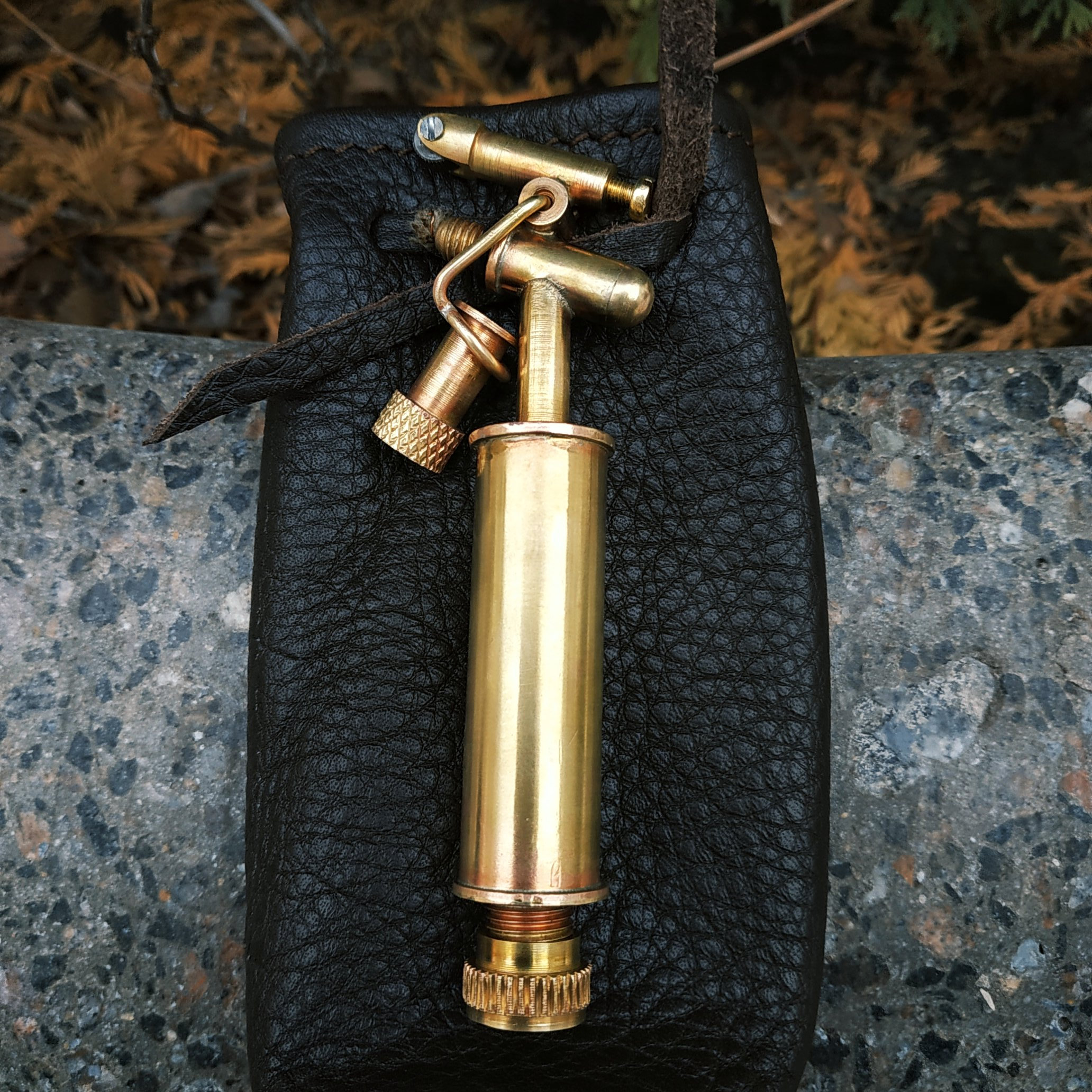 golden lighter with black leather pouch